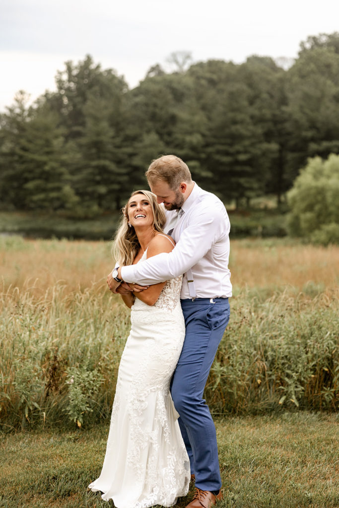 bride and groom in field smiling