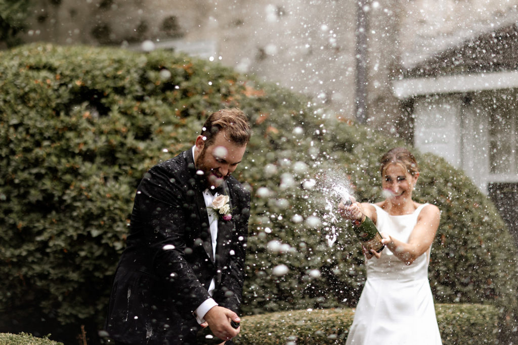 Bride and groom popping champagne 
